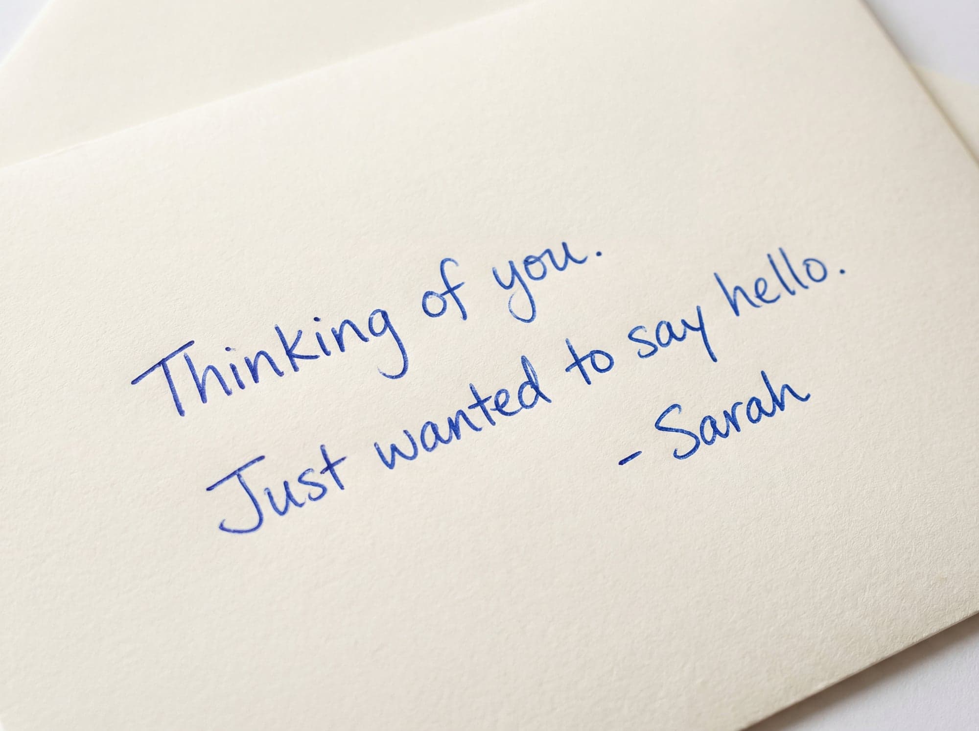 Close-up of a blue handwritten note on textured paper